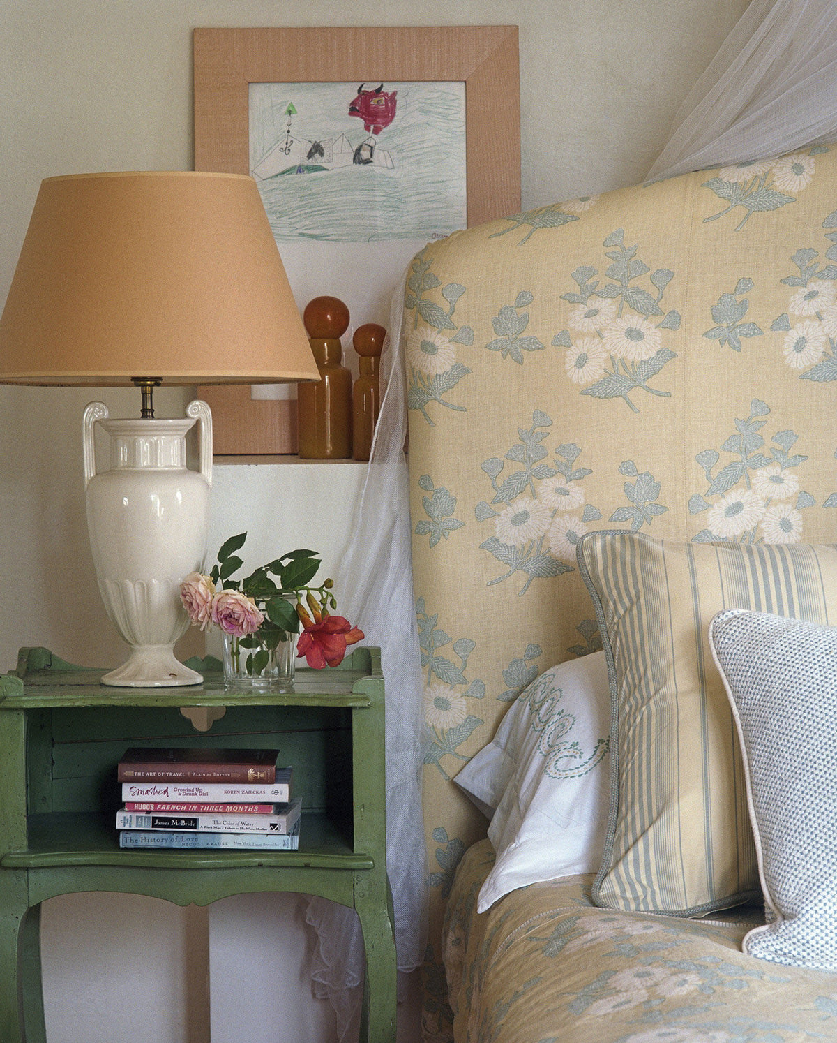 An upholstered bed with a Floral Batik Yellow headboard and bed covering designed by Kathryn M. Ireland