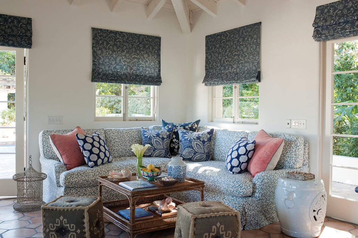 A bright, sunlit living room featuring Greta Indigo window blinds designed by Kathryn M. Ireland