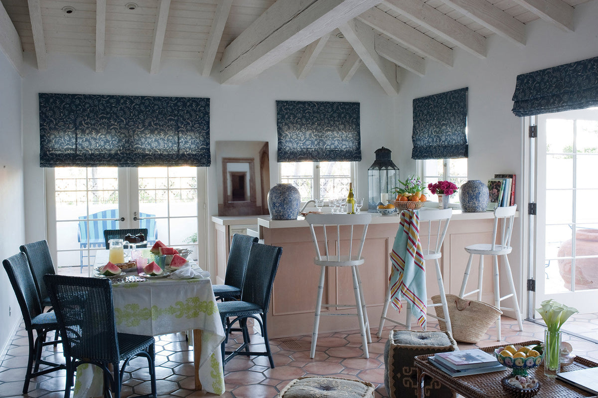 A dining room and bar featuring window shades in Greta Indigo designed by Kathryn M. Ireland