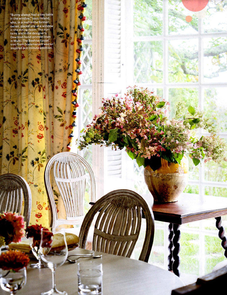 A page in House Beautiful magazine featuring a dining room in a Cape Cod home designed by Kathryn M. Ireland.