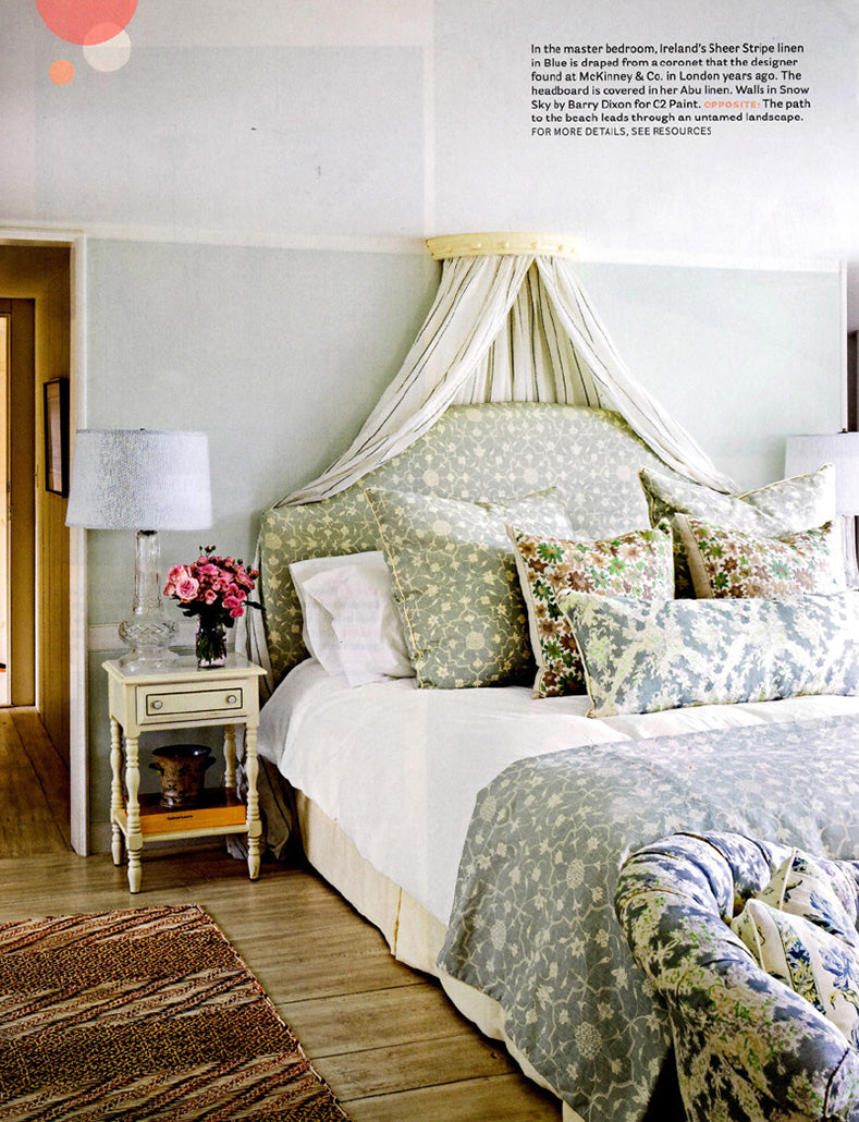 A bedroom in a home designed by Kathryn M. Ireland on Cape Cod in House Beautiful magazine featuring Sheer Stripe in Blue bed drapes and a headboard and bed linen in Abu Fog.