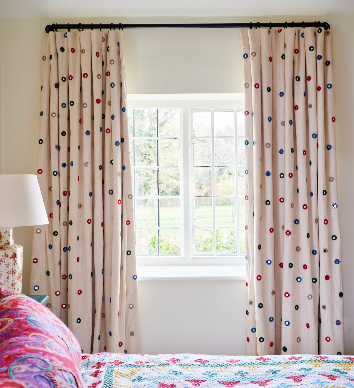 A pair of floor-length curtains in Indian Mirror Multi designed by Kathryn M. Ireland