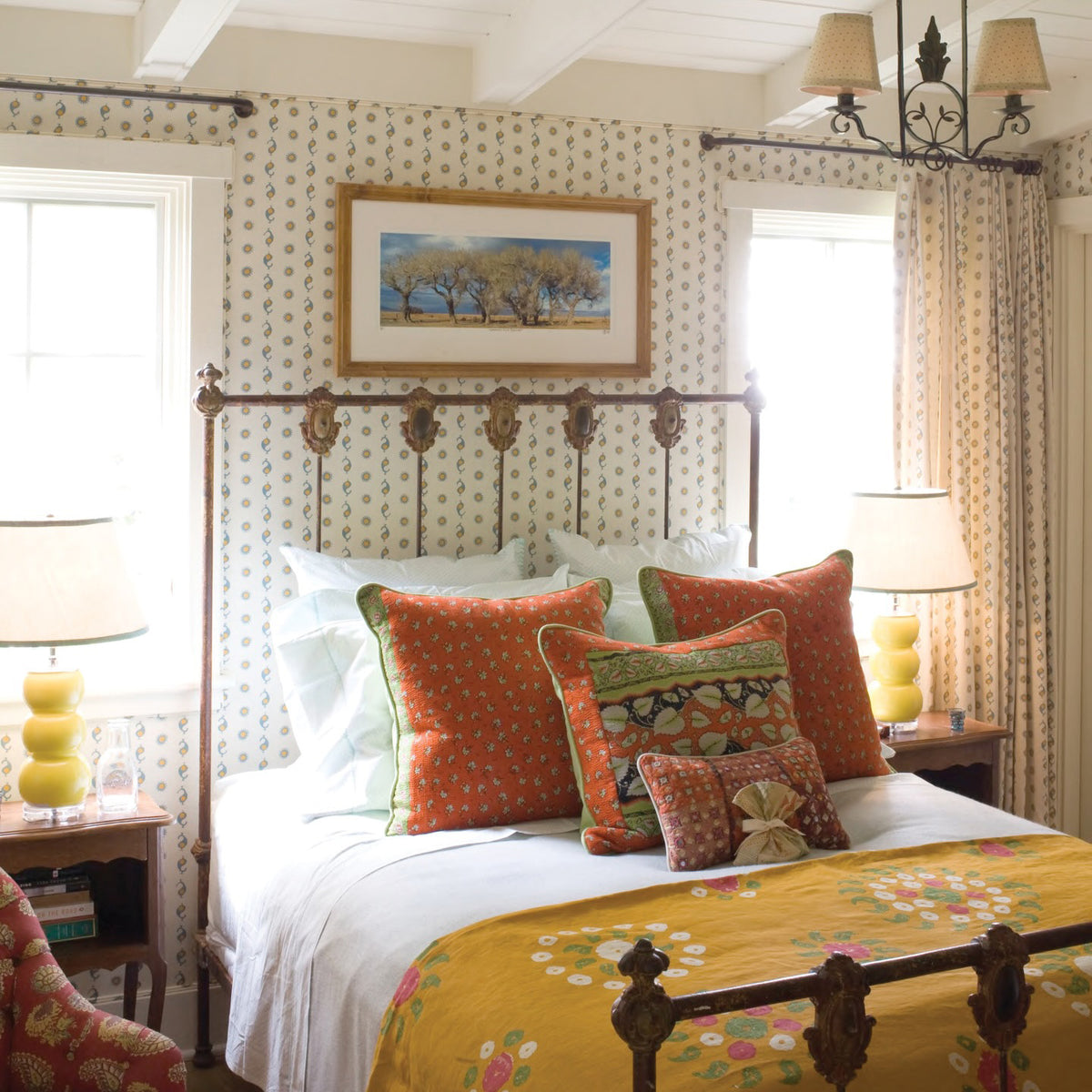 A bedroom designed by Kathryn M. Ireland featuring Casablanca Natural/Sky & Mustard wallpaper and curtains, and a Marrakech Tangelo fabric bedspread.