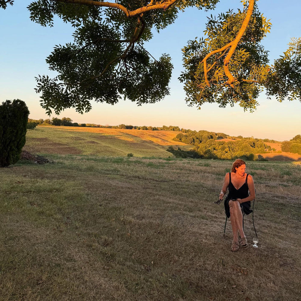 Kathryn M. Ireland sits in a lush field at her home, La Castellane, in the south of France.