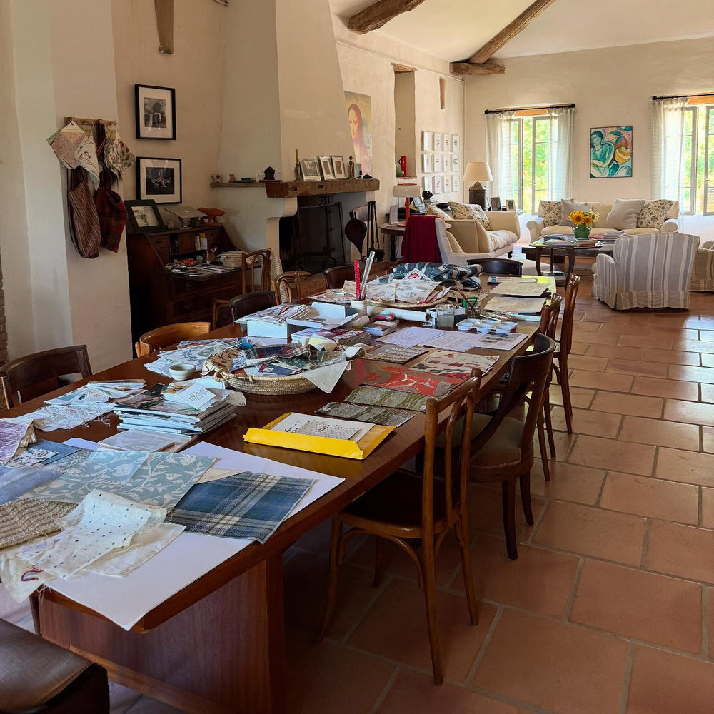 A long table in Kathryn M. Ireland's home in the south of France covered in fabric and wallpaper samples.