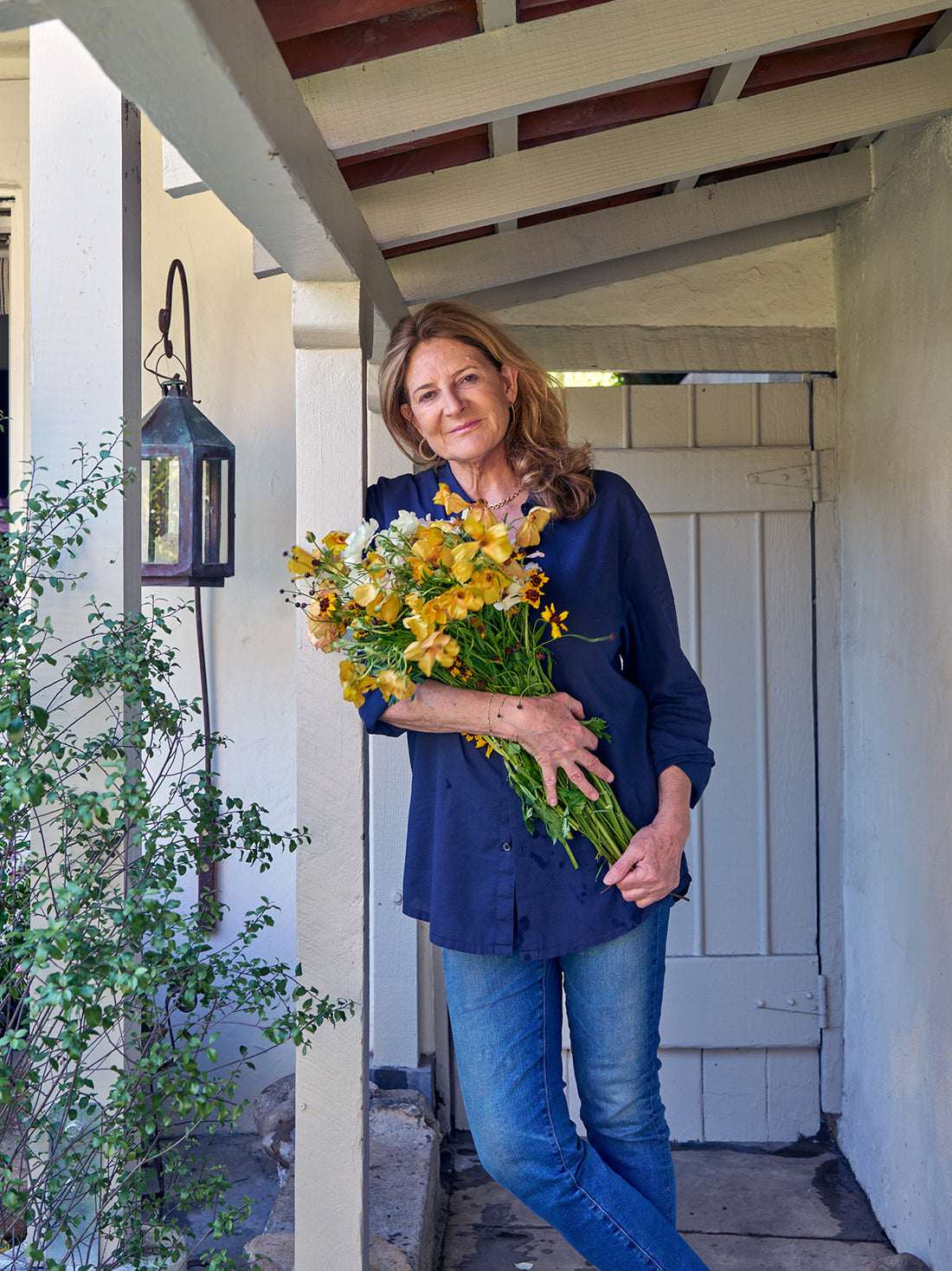 Portrait of designer Kathryn M. Ireland holding a bouquet of flowers