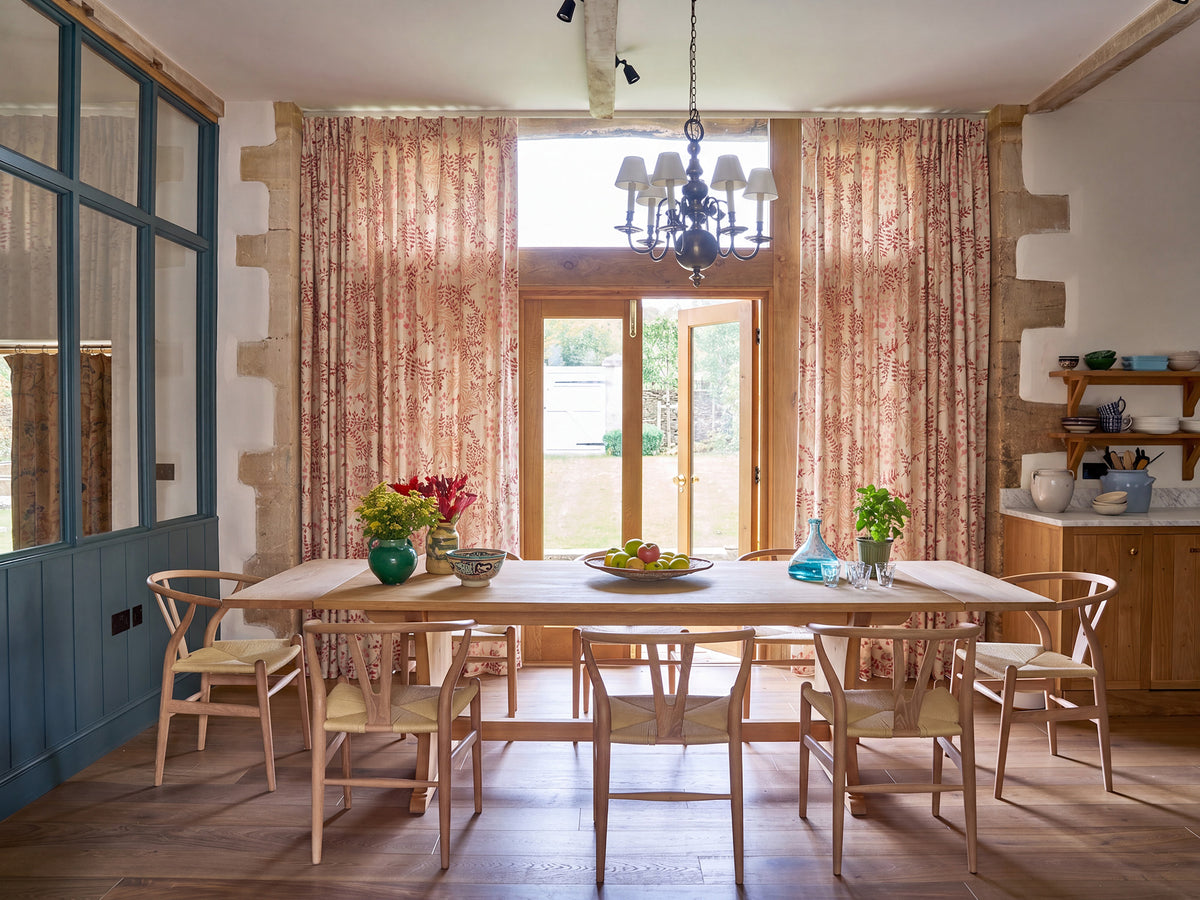 A dining room featuring Leaves Red on Ochre curtains designed by Kathryn M. Ireland