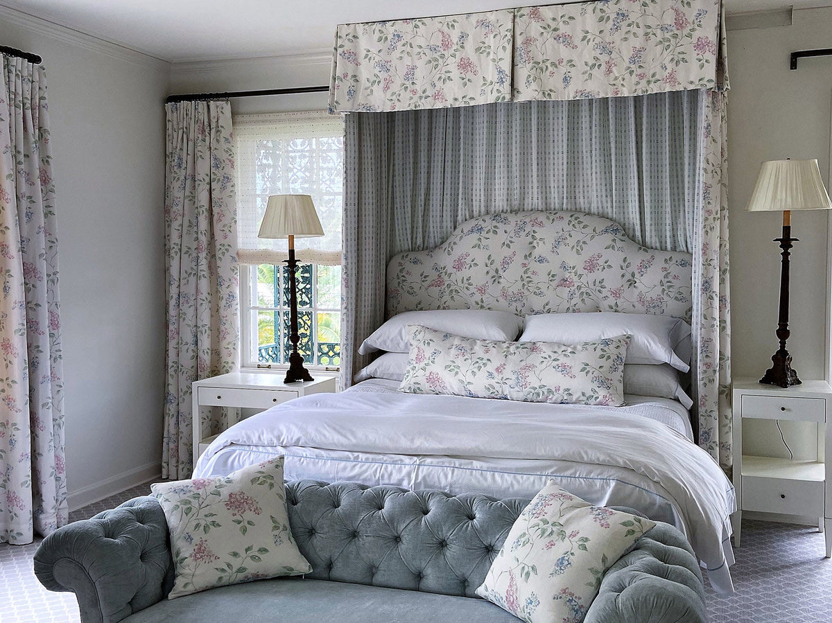 A bedroom with a canopy bed featuring Llilac Multi and Bamboo Blue bed curtains designed by Kathryn M. Ireland