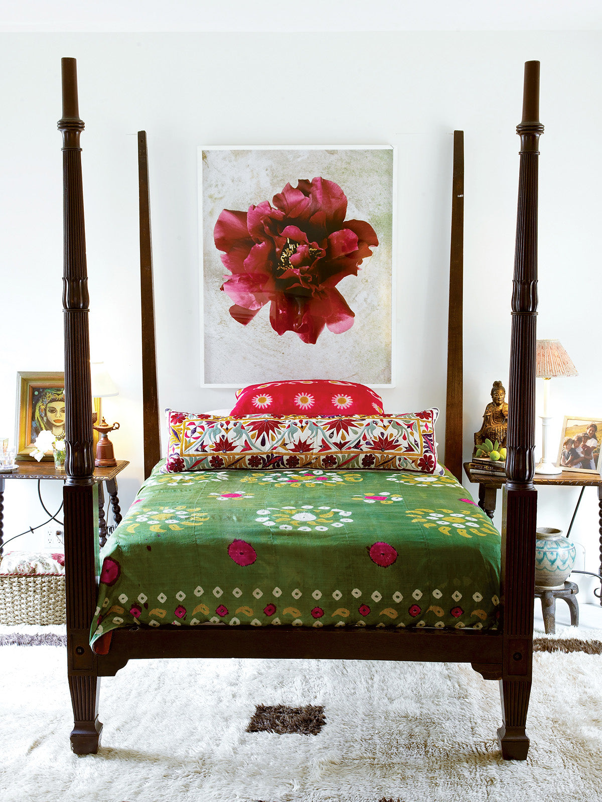 A dark wood four-poster bed styled with a Marrakech Margarita Green quilt designed by Kathryn M. Ireland