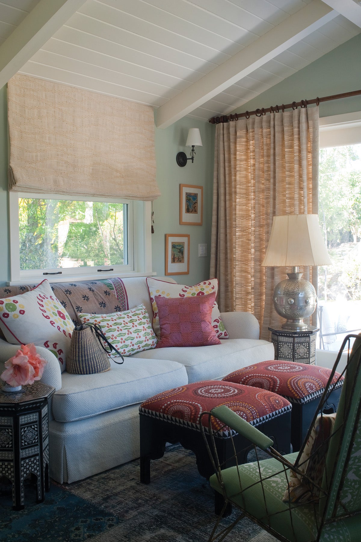 A living room interior featuring a light gray sofa with Moroccan Weave Natural curtains and window blinds designed by Kathryn M. Ireland