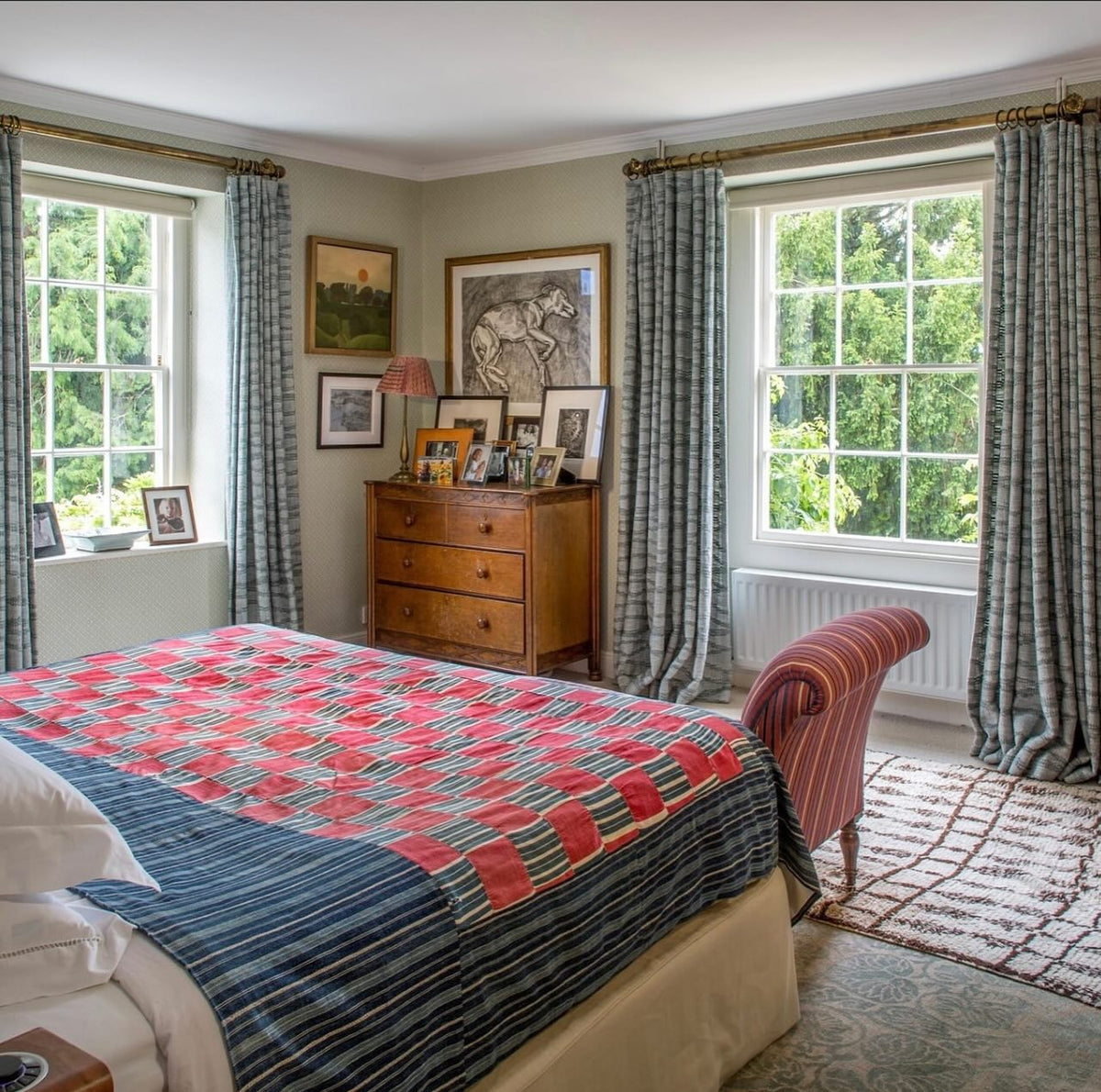 A bedroom featuring Moroccan Weave Blue curtains, designed by Kathryn M. Ireland.