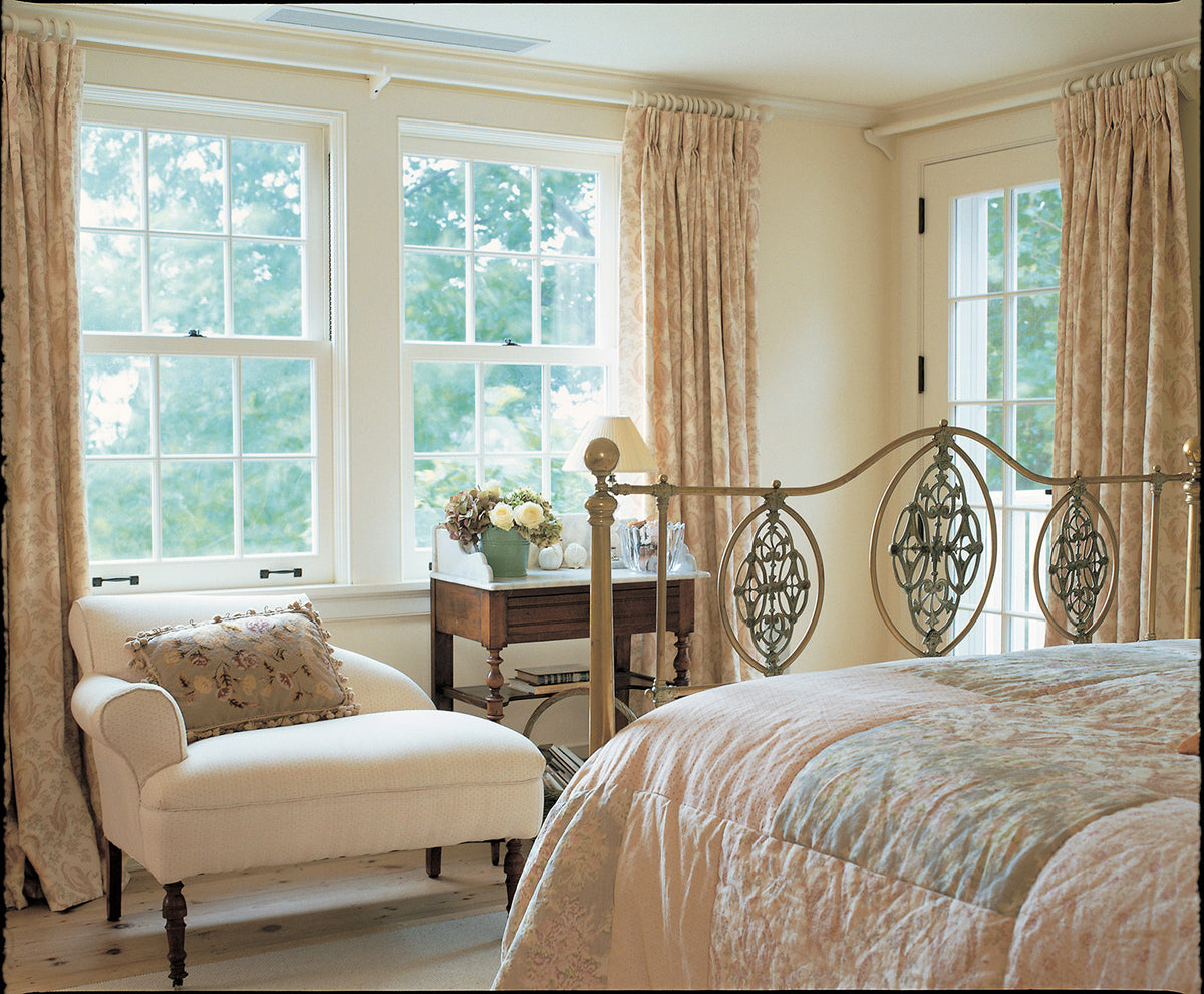 A styled bedroom interior featuring Paisley Stripe Red curtains designed by Kathryn M. Ireland