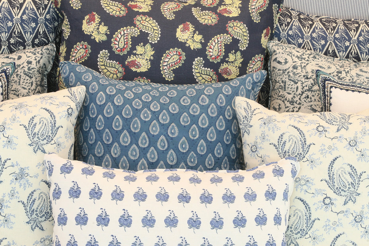 A collection of decorative throw pillows in various patterns and colors, including Paisley Stripe Indigo, Quilt Indigo, and Diamond Batik Indigo designed by Kathryn M. Ireland