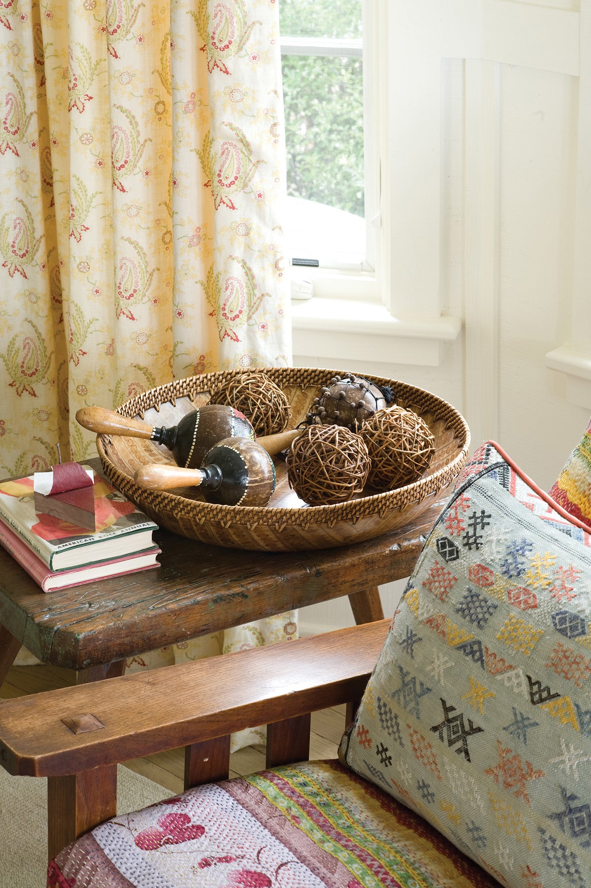 A paisley stripe red curtain behind a chair designed by Kathryn M. Ireland