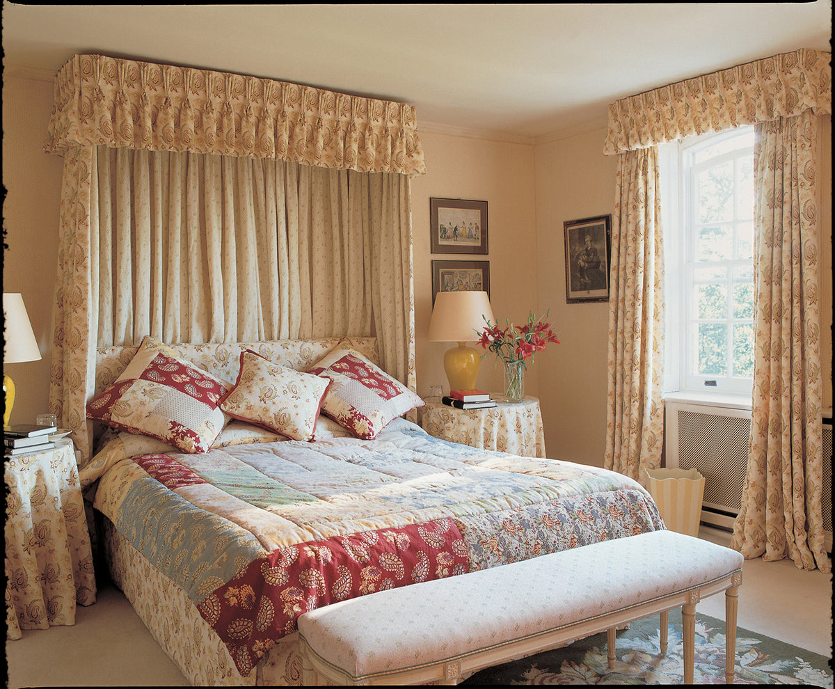 A bedroom featuring Paisley Stripe Red bed canopy, pillows, and curtains designed by Kathryn M. Ireland