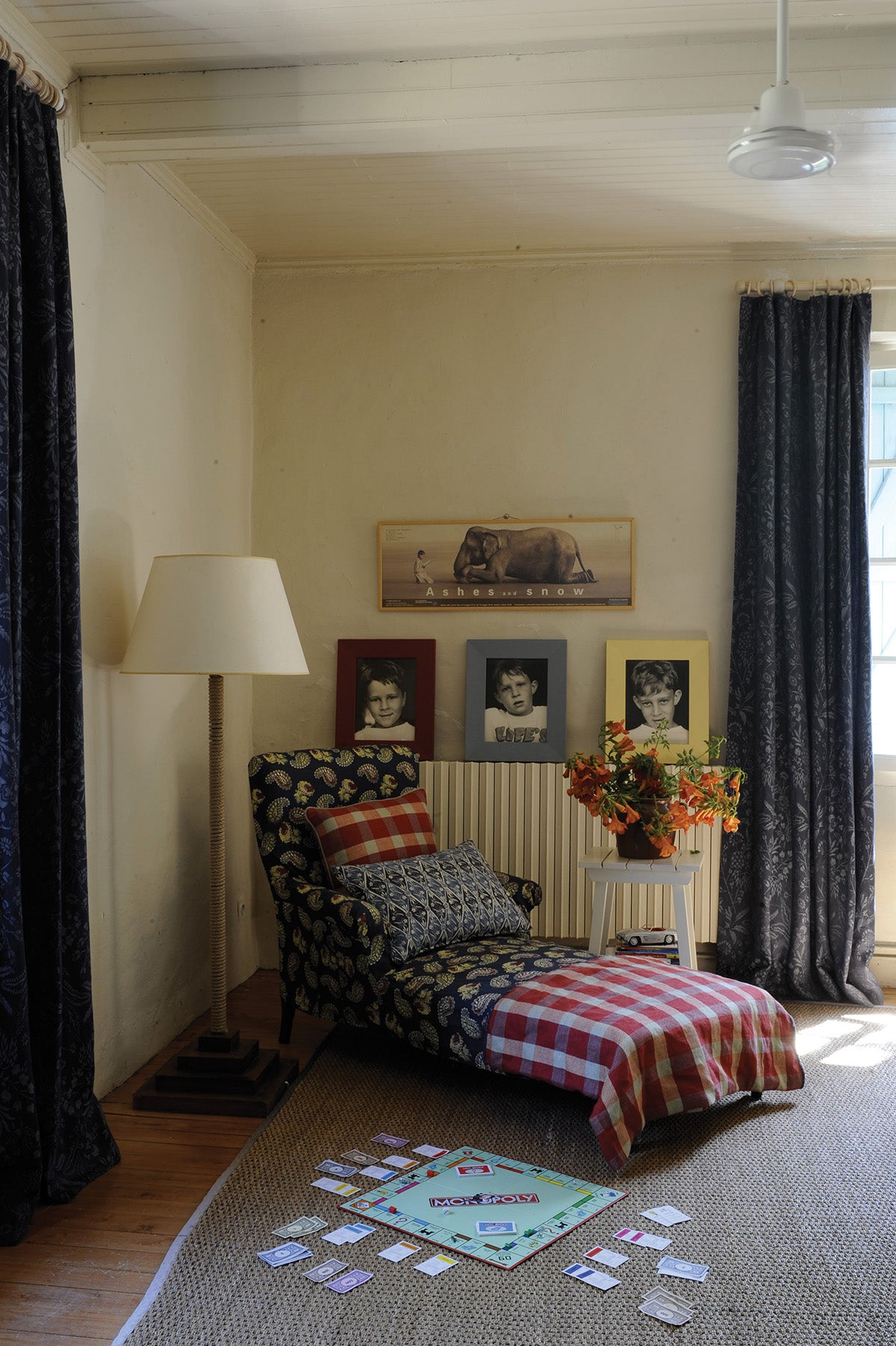 A cozy, vintage-style room corner featuring a floral-patterned chaise lounge in Quilt Indigo and Diamond Batik Indigo designed by Kathryn M. Ireland 