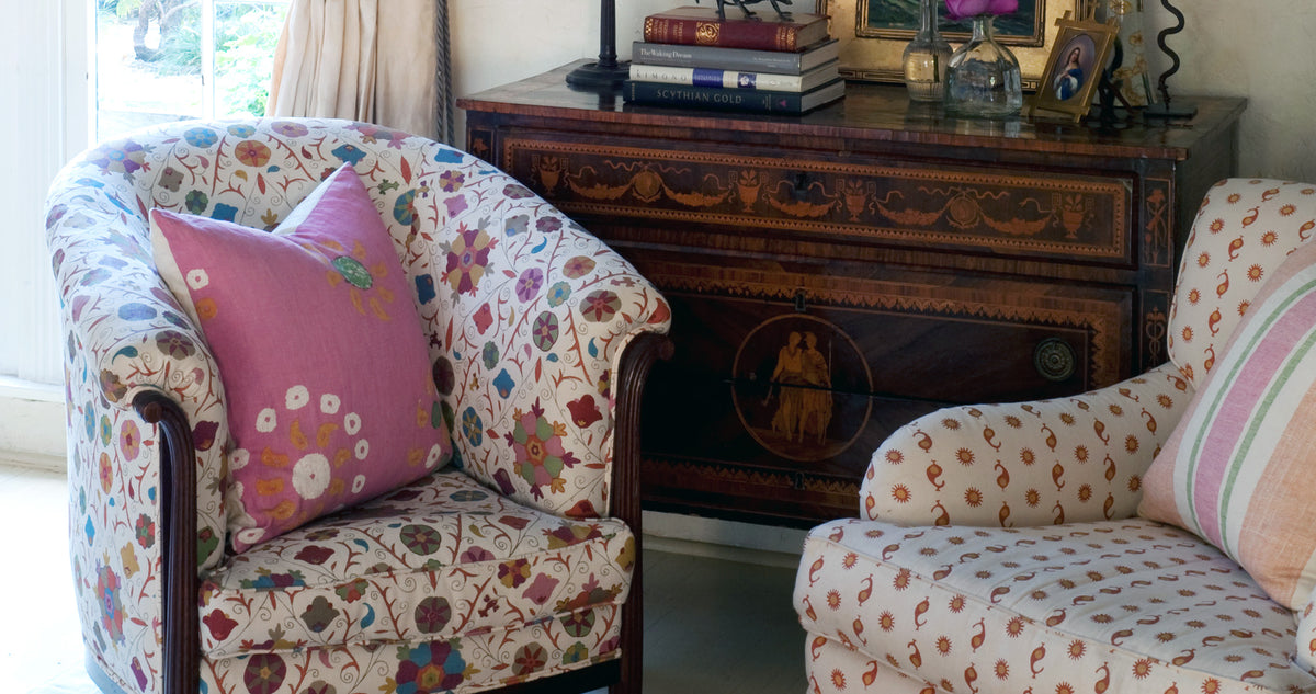 An arm chair in Safi Suzani Fiesta on White, an arm chair in Natural Casablanca Flame & Mustard, and a pillow in Marrakech Bubblegum Pink designed by Kathryn M. Ireland