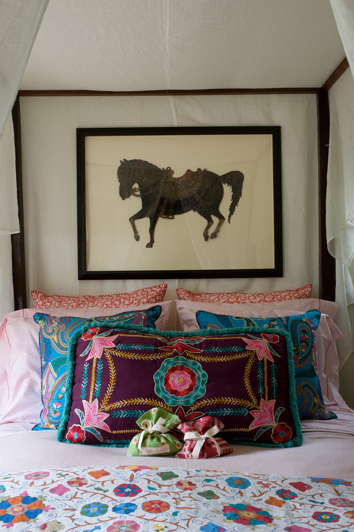 A styled bed with Safi Suzani Fiesta bedspread designed by Kathryn M. Ireland