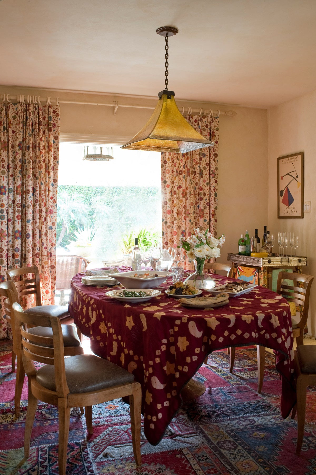 A dining room featuring Safi Suzani Chocolate Cherry curtains designed by Kathryn M. Ireland