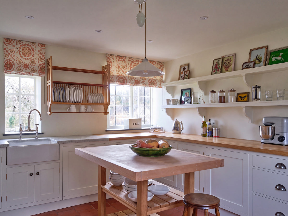 A kitchen featuring roman shades in Sultan Suzani Sienna designed by Kathryn M. Ireland