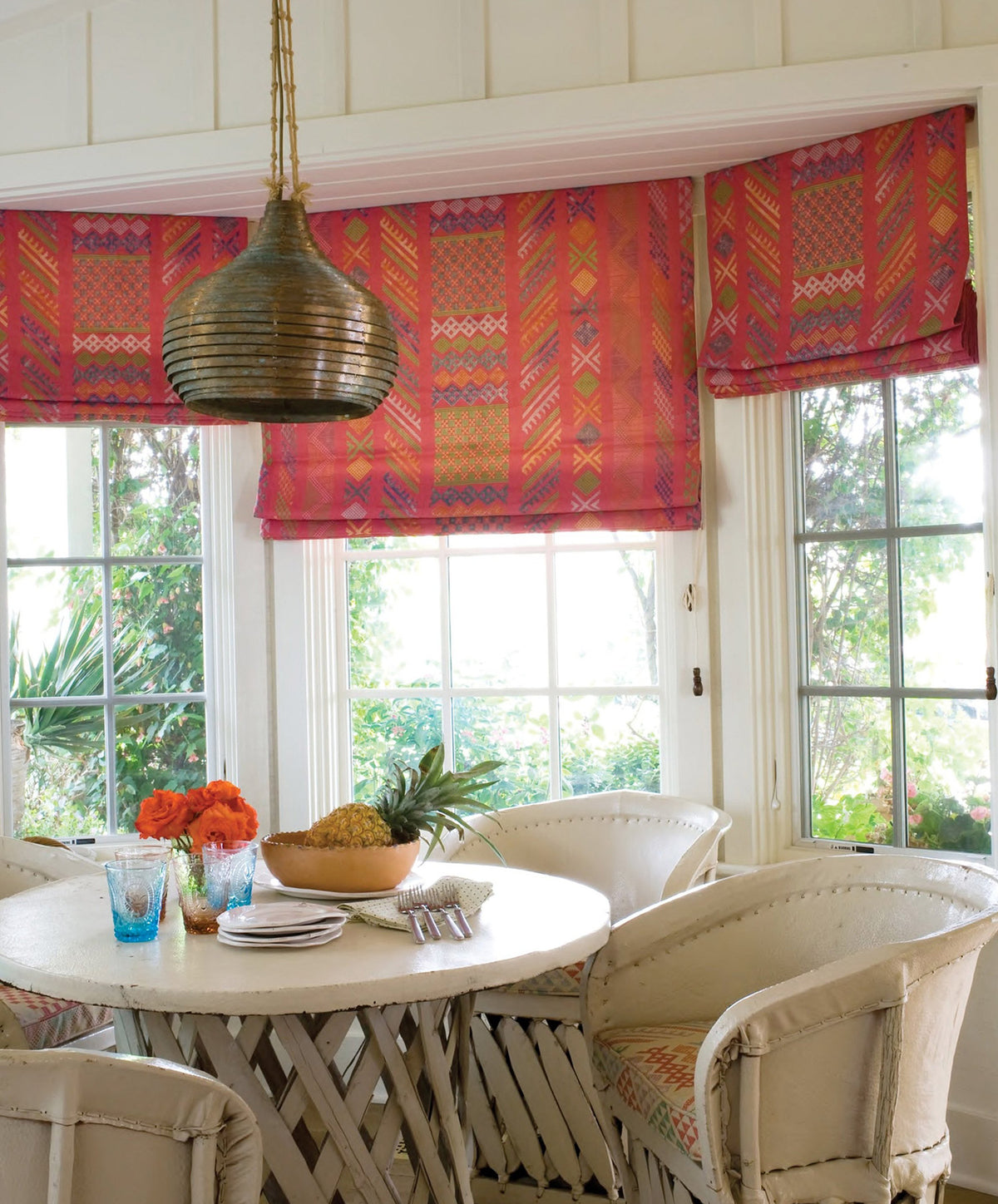 A dining area featuring Tangier Multi Peony Multi Roman Shades designed by Kathryn M. Ireland