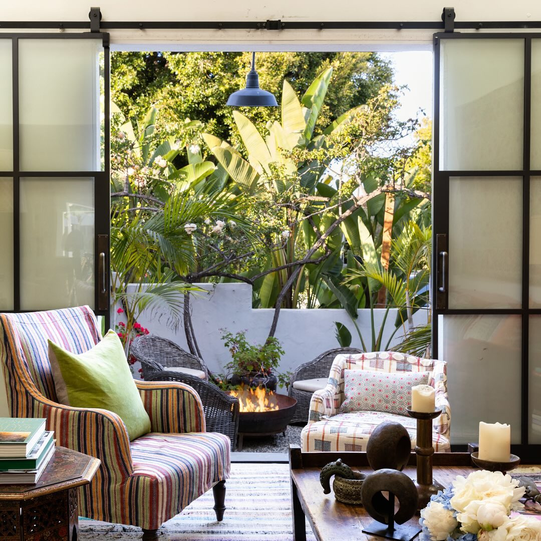 An interior of Kathryn M. Ireland's Santa Monica home featuring an arm chair in Ottoman Stripe Royal Multi, and a low arm chair in Togo Check Multi fabric.