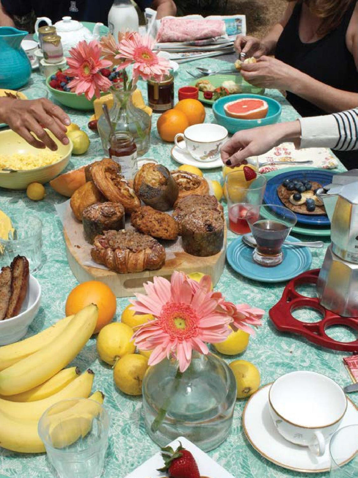 A breakfast spread on a Wildflowers Turquoise tablecloth designed by Kathryn M. Ireland